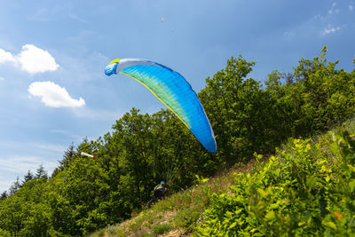 The man losing control during the start with the paraglider, the parachute bowl lies on the tree.