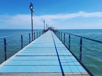 Pier on sea against blue sky