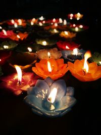 Close-up of illuminated candles on black background