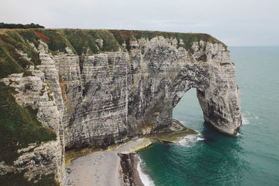 Rock formations by sea against sky