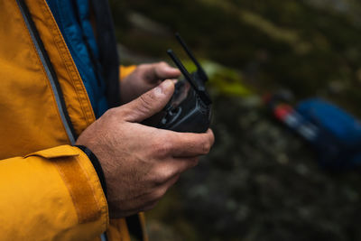 Midsection of person holding remote control