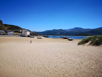 Scenic view of beach against clear blue sky