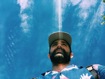 Low angle view of man against blue sky