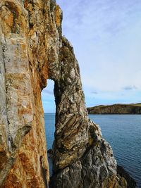 Natural stone arch formation with coastal view in background. anglesey uk