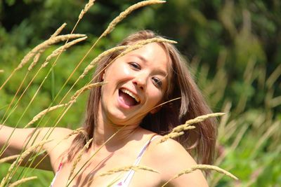 Portrait of smiling young woman against plants