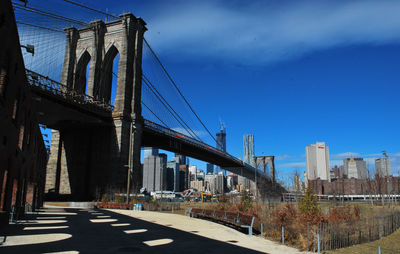 Brooklyn bridge by city against sky