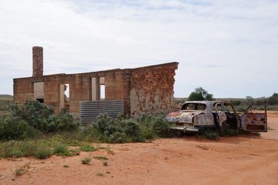 Abandoned car against sky