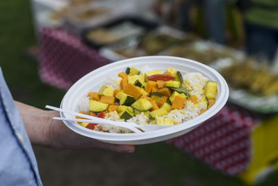 Cropped image of person holding food in plate