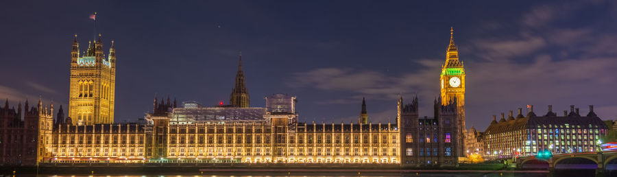 Illuminated buildings in city against sky at night