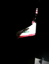 Close-up of illuminated lamp over black background