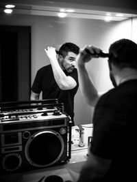 Man cutting hair while looking in mirror