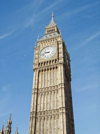 Low angle view of clock tower against blue sky