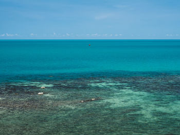 Minimal scenic view of crystal clear turquoise sea with faraway fishing boat. koh samui, thailand.