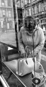 Reflection of man photographing on glass window