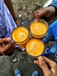 Low section of friends toasting drink glasses