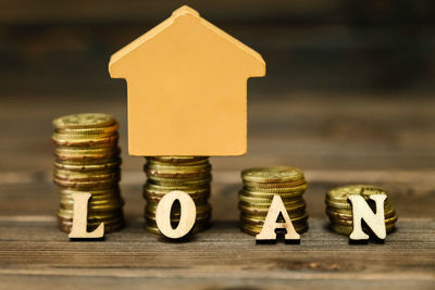 Close-up of coins with model home and loan text on table