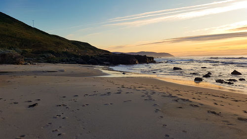 Scenic view of beach against sky during sunset