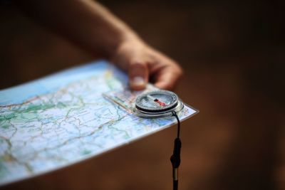 Hand holding map and compass