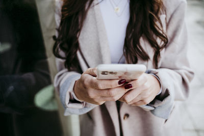 Midsection of woman holding coffee cup