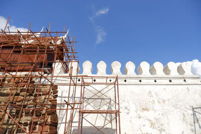 Low angle view of construction site against clear blue sky