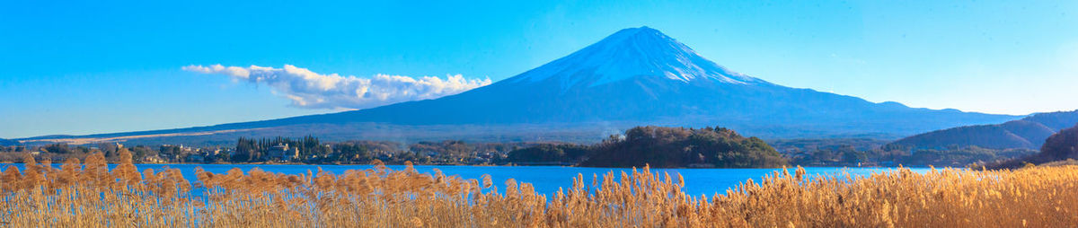 Panoramic view of lake and mountains against blue sky