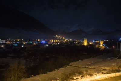 Illuminated city against sky during winter