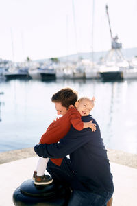 Rear view of father with son on shore