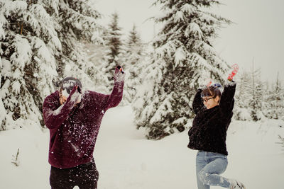 Couple in love playing on snow covered field