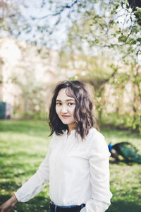 Happy young woman in a white blouse in a park. springtime