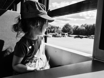 Portrait of girl looking through window