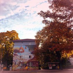 Trees in front of building against sky