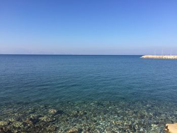 Scenic view of sea against clear blue sky