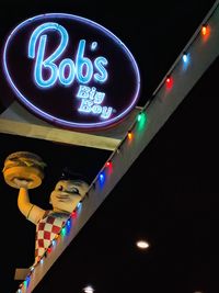 Low angle view of illuminated neon sign at night