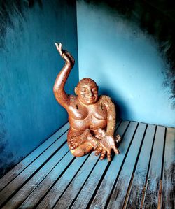 Sculpture on wooden table against wall