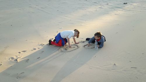 High angle view of sibling playing on beach