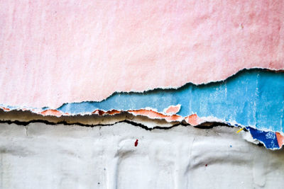 Close-up of torn papers on weathered wall