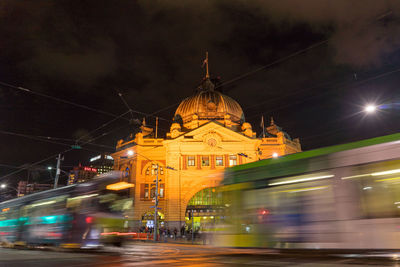 Blurred motion of illuminated city against sky at night