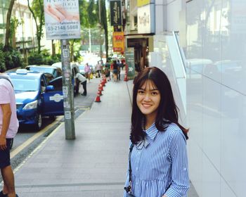 Portrait of woman standing in city