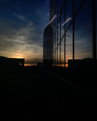 Silhouette buildings against sky at sunset