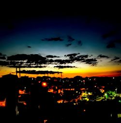 Illuminated cityscape against sky at night
