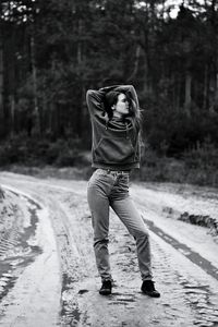 Carefree young woman standing on dirt road