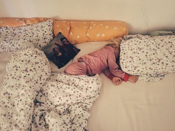 High angle view of girl sleeping on bed at home