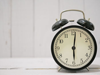 Close-up of alarm clock against wall