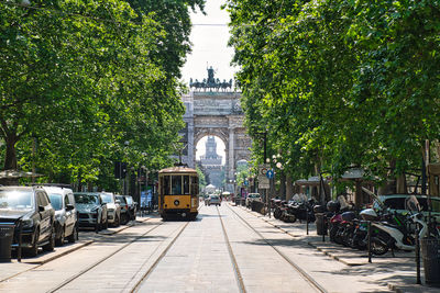 An old traditional tram is passing by corso sempione avenue