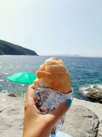 Close-up of woman holding ice cream on beach