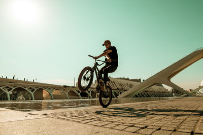 Man riding bicycle against clear sky