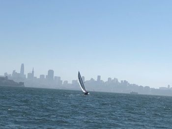 Scenic view of sea by buildings against clear sky