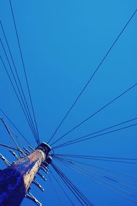 Low angle view of electricity pylon against blue sky