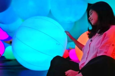 Low angle view of girl playing with balloons