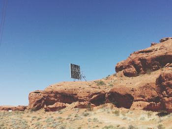 Low angle view of rock formation against clear blue sky